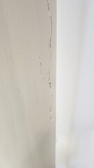 Cracks inside the building. Cracks on the walls inside the room near the house pillars, Building problems and solutions concept. Paint peeling off the walls. Damage from subsidence, vibrations.

