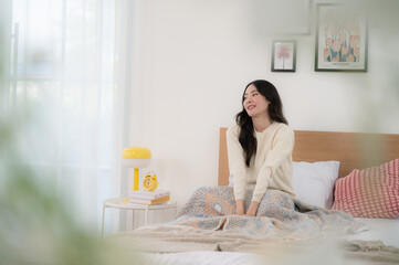 A beautiful woman wakes up in her bed. Her dress looks soft and comfortable.