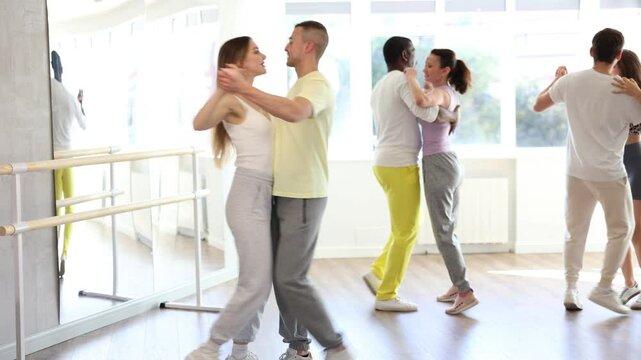  Couple of adult man and adult woman dancing waltz in studio