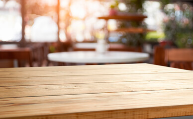 Empty wooden table with a blurred cafe setting in the background.