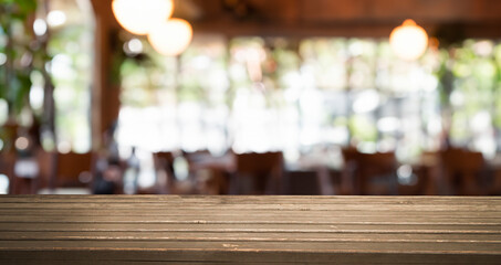 A wooden table top with a blurred background of a restaurant interior.