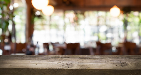 Rustic wooden table top with a blurred background of a restaurant interior. Perfect for showcasing your products.