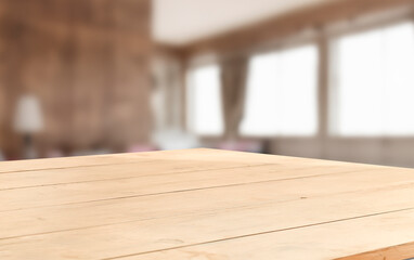 A wooden table top with a blurred background of a living room.