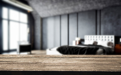 Rustic wooden table top with a blurred background of a modern bedroom.