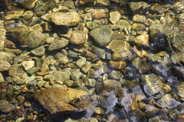 water reflection of sun light and river pebbles shining