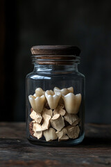 Human teeth in a glass jar. Isolated dark background. Dental health and forensics. Ethical implications of dental records and privacy. 
