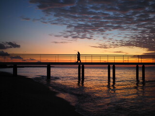 sunset, pier, sea, beach, ocean, sky, sun, beautiful, calm, horizon, red, blue, landscape, coast, bridge, water, purple, clouds, peopleshadow, shadow, impressive, scenary.