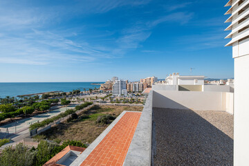 Scenic coastal cityscape featuring a vibrant blue ocean, lined with lush greenery and white buildings, under a clear blue sky portraying a serene and picturesque urban environment in Vinaroz Valencia