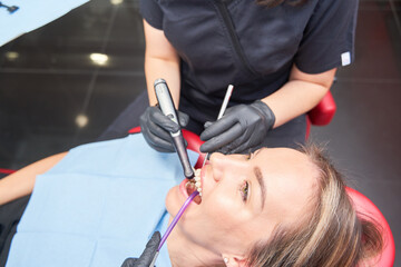 woman patient at the dentist having a dental intervention with a female dentist