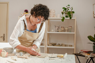 Potter molding clay in ceramics workplace