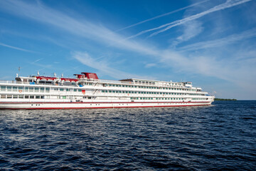 A large cruise ship moves smoothly over the water, showcasing its sleek design and vibrant colors...