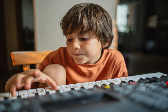 Boy practicing synthesizer at home