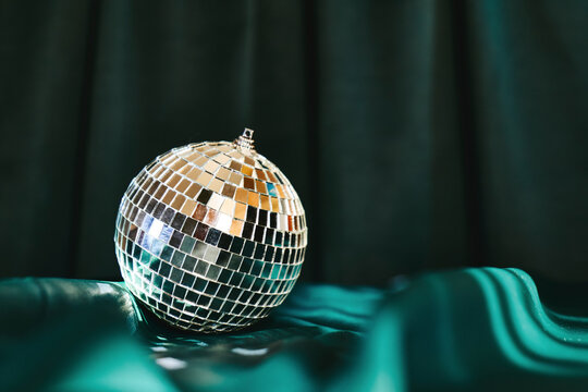 Shiny disco ball on green cloth