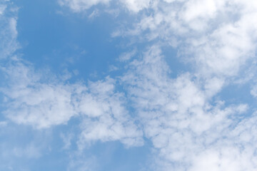 Blue sky with fluffy white clouds on a sunny summer day. Soft fluffy clouds in the blue sky