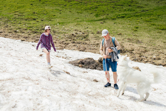 Father and daughter with dog standing on patch of snow