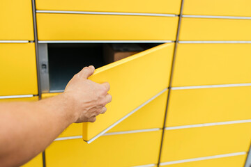 Hand of man opening door of mailbox