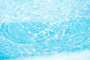 Blue water with ripples on the surface. Defocus blurred transparent blue colored clear calm water surface texture with splashes and bubbles. Water waves with shining pattern texture background.