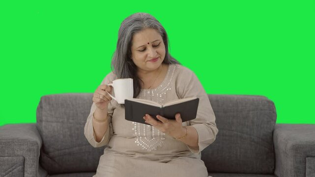 Happy Indian old woman reading a book in morning Green screen