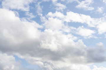 Fluffy white clouds, against a bright blue sky, with little editing.