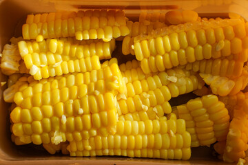 Photo of corn that has been peeled and cut into pieces and placed in a food container.