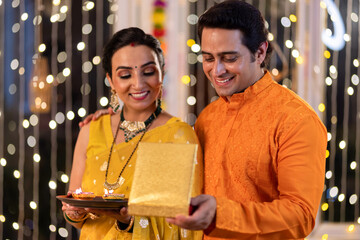 Loving man gifting necklace to wife at home during Diwali festival