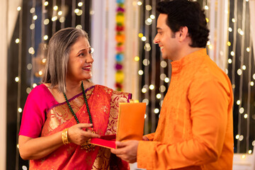 Obraz premium son giving diwali gift to mother at home