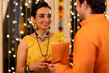 Loving man gifting necklace to wife at home during Diwali festival
