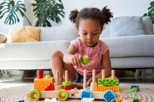Girl playing with toys on rug at home