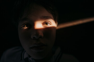Teenage boy with spot of light on eye