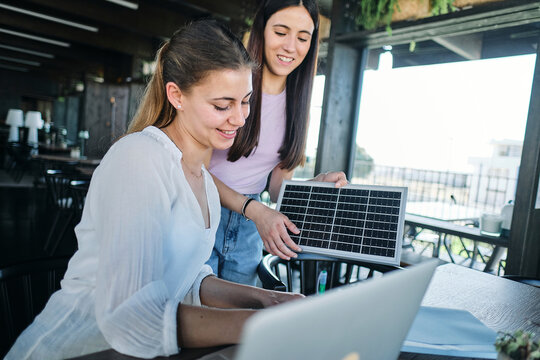 Two young women working together on sustainable resources project at coworking space