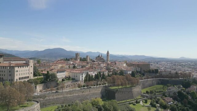 Approach to the medieval city of Bergamo Alta nestled on the green hills, near Orio al Serio Airport during a beautiful sunny day