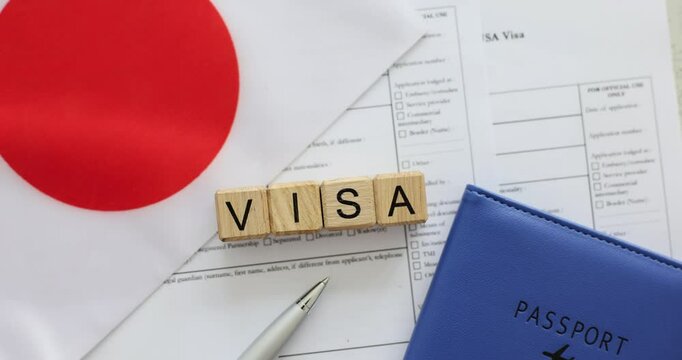 Word Visa made from wooden cubes on Japanese flag and application papers. Concept of preparation essential documents for safe travel experience
