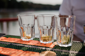Refreshing Summer Cocktails with Citrus Garnish on a Bar Table by the Water