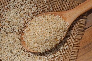 topview of sesame seeds in a wooden spoon