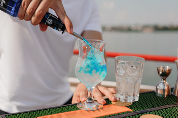 Refreshing Tropical Cocktail Being Prepared on a Sunny Day by a Waterfront Bar