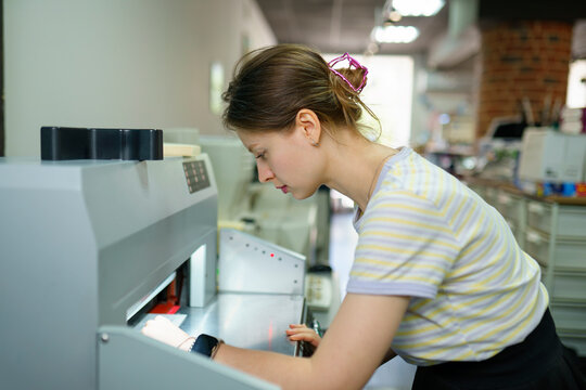 Woman using printer in a printing shop