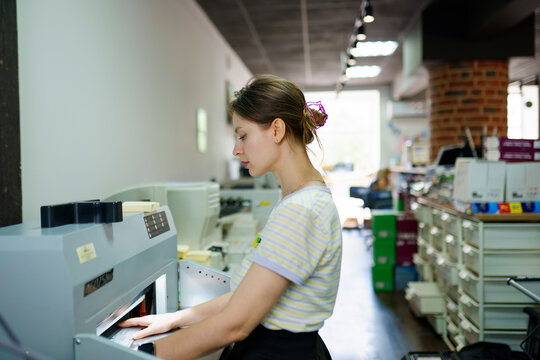 Woman using printing machine at a printing shop
