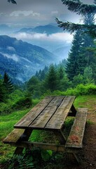 Fototapeta premium A wooden picnic table sits in a clearing in the forest with a stunning view of the mountains in the distance.
