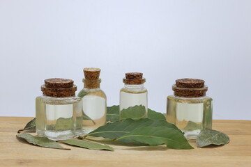 daphne leaves and essential oil in bottles on white background