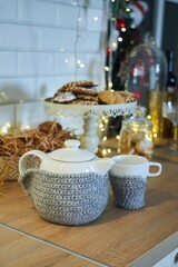 Tea kettle and cup on the festive table, desserts. New Year or Christmas