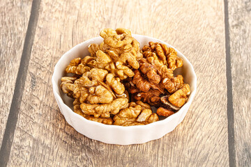 Cracked unshelled walnut in the bowl