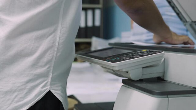 Close up, Hand of man press buttons on photocopier machine to copy or scanning document in office.Businessman copy document at workplace. Businessman working in Office.