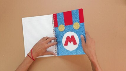 Making handmade notebook with blue video game themed design