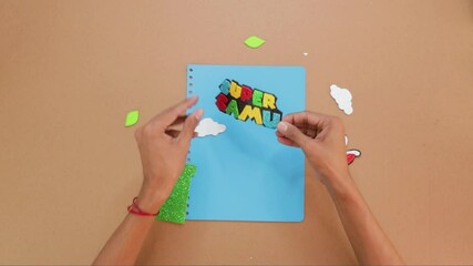Gluing paper art letters to custom made notebook cover, video game themed kids notebook