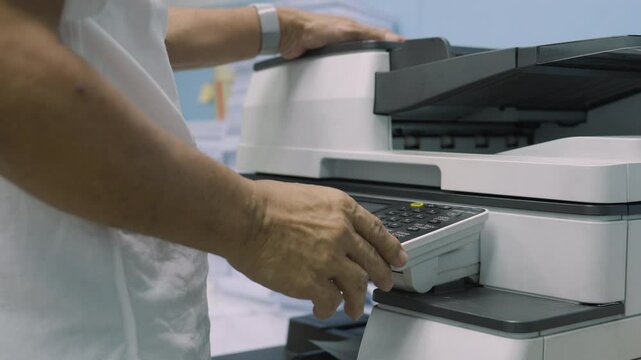 Close up, Hand of man press buttons on photocopier machine to copy or scanning document in office.Businessman copy document at workplace. Businessman working in Office.