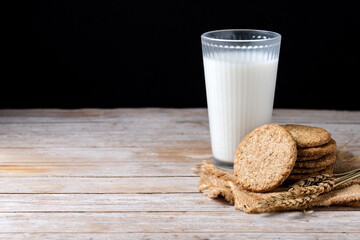 Healthy oatmeal cookies and milks on wooden table. Copy space