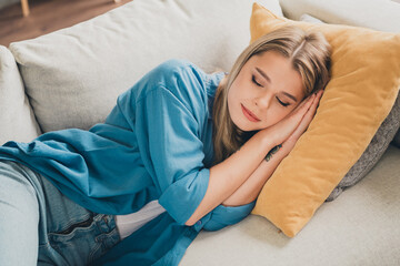 Photo of young dreaming blonde hair woman chilling at home laying down comfortable soft couch and pillow sleeping indoors living room