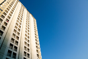 Obraz premium low angle view of apartment building corner against clear blue sky