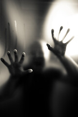 Scary picture of hands behind glass, horror ghost behind door, Halloween concept