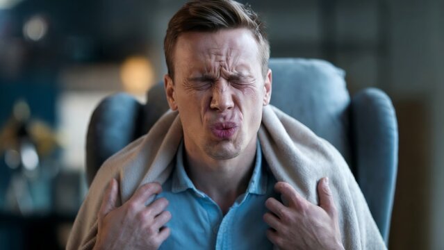 Man with sore throat in cozy setting. Cinematic style. Health and comfort concept. For health awareness and wellness uses. Suitable for banners, posters, cards.